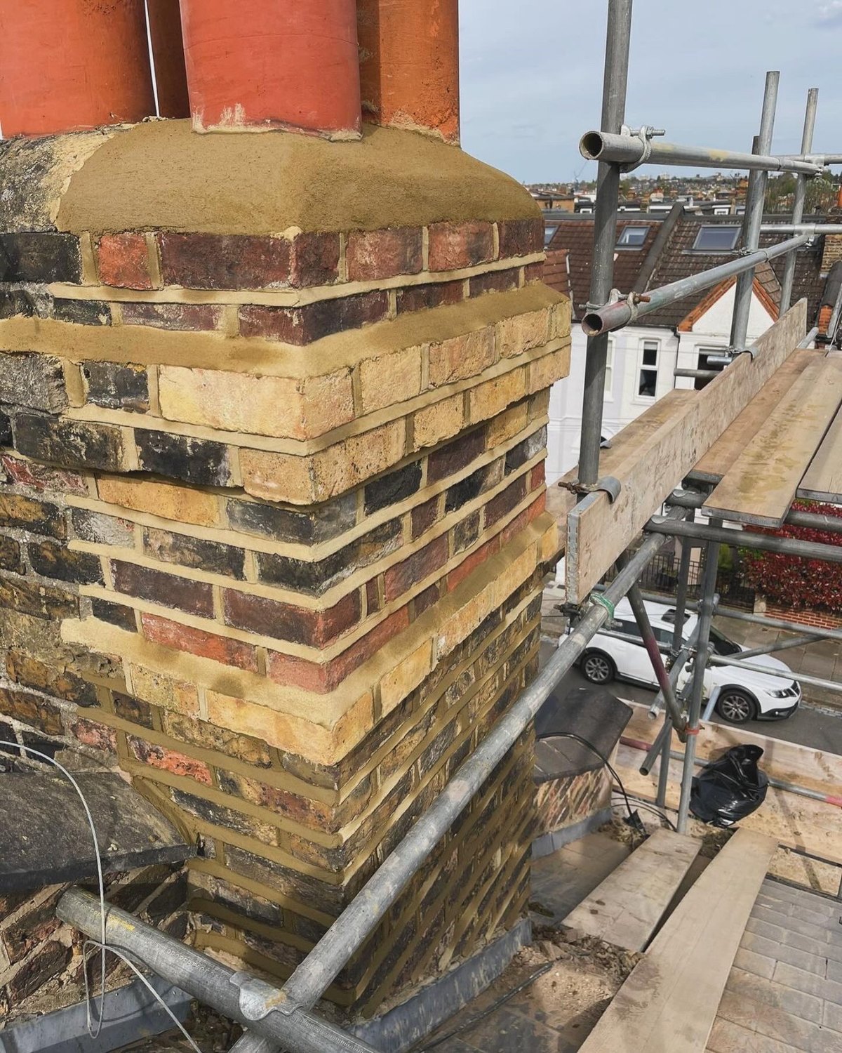A rebuilt brick chimney stack with new pots and flashing