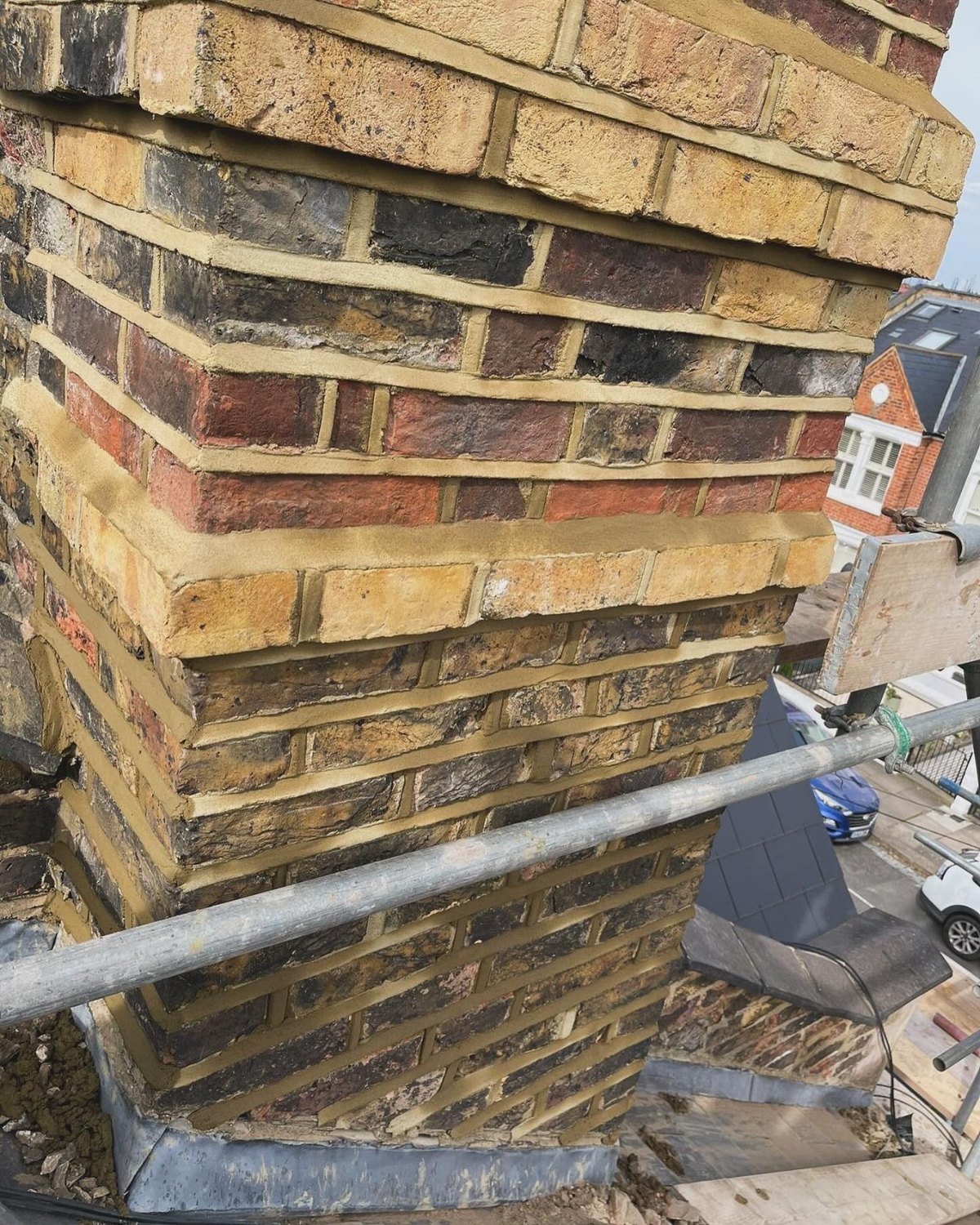 A rebuilt brick chimney stack with new pots and flashing