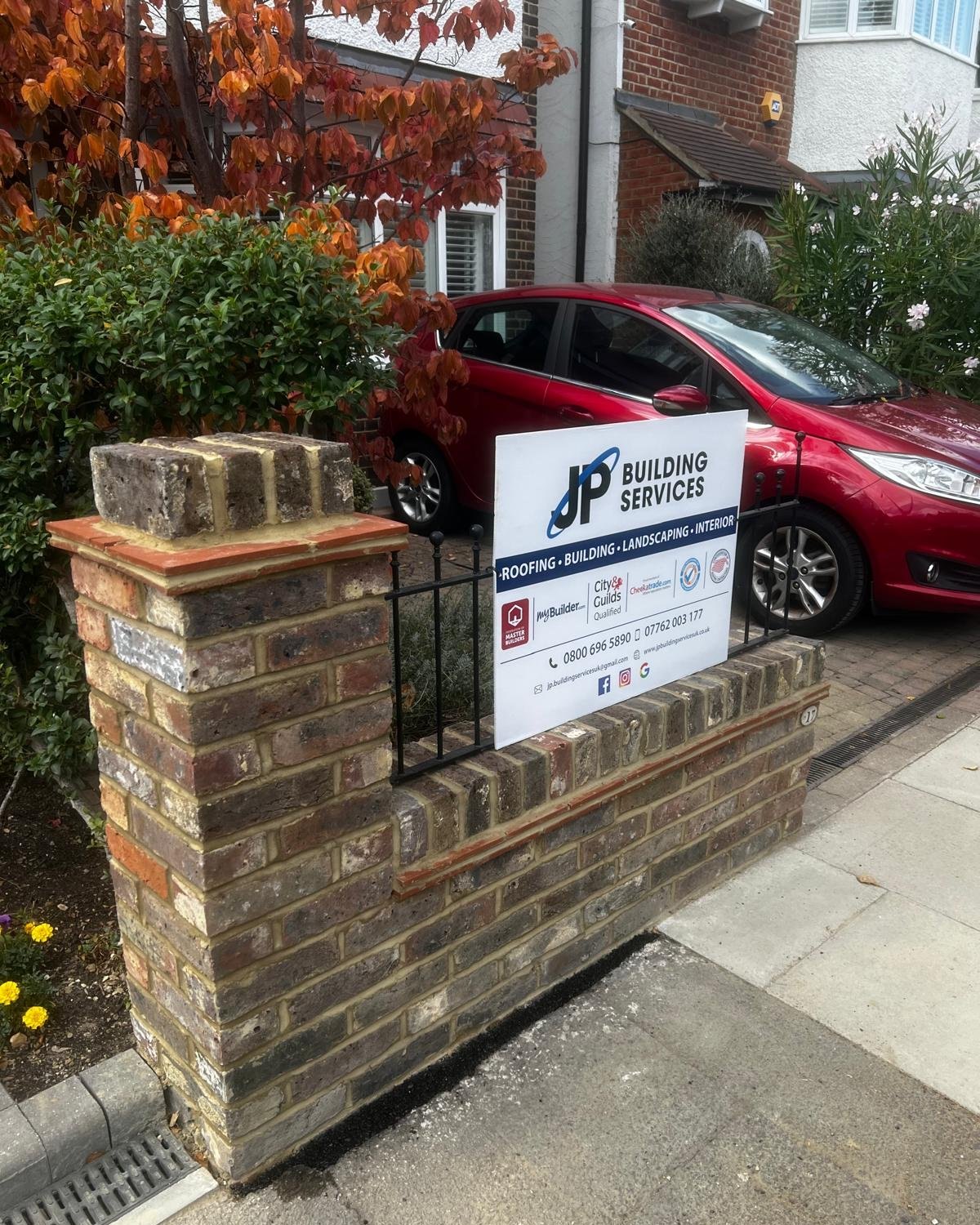 A bricklayer repointing a brick wall